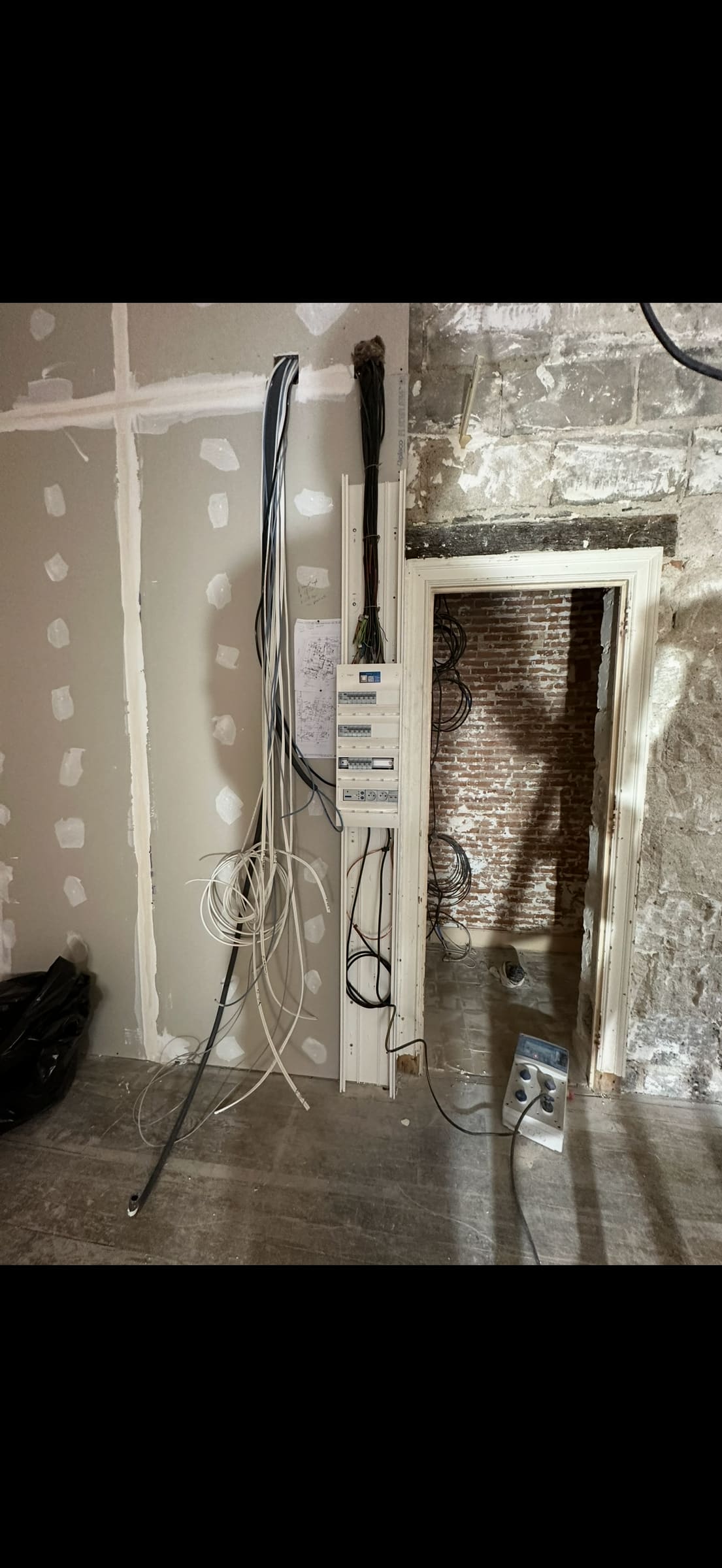Tableau électrique posé dans une cloison en cours de travaux
