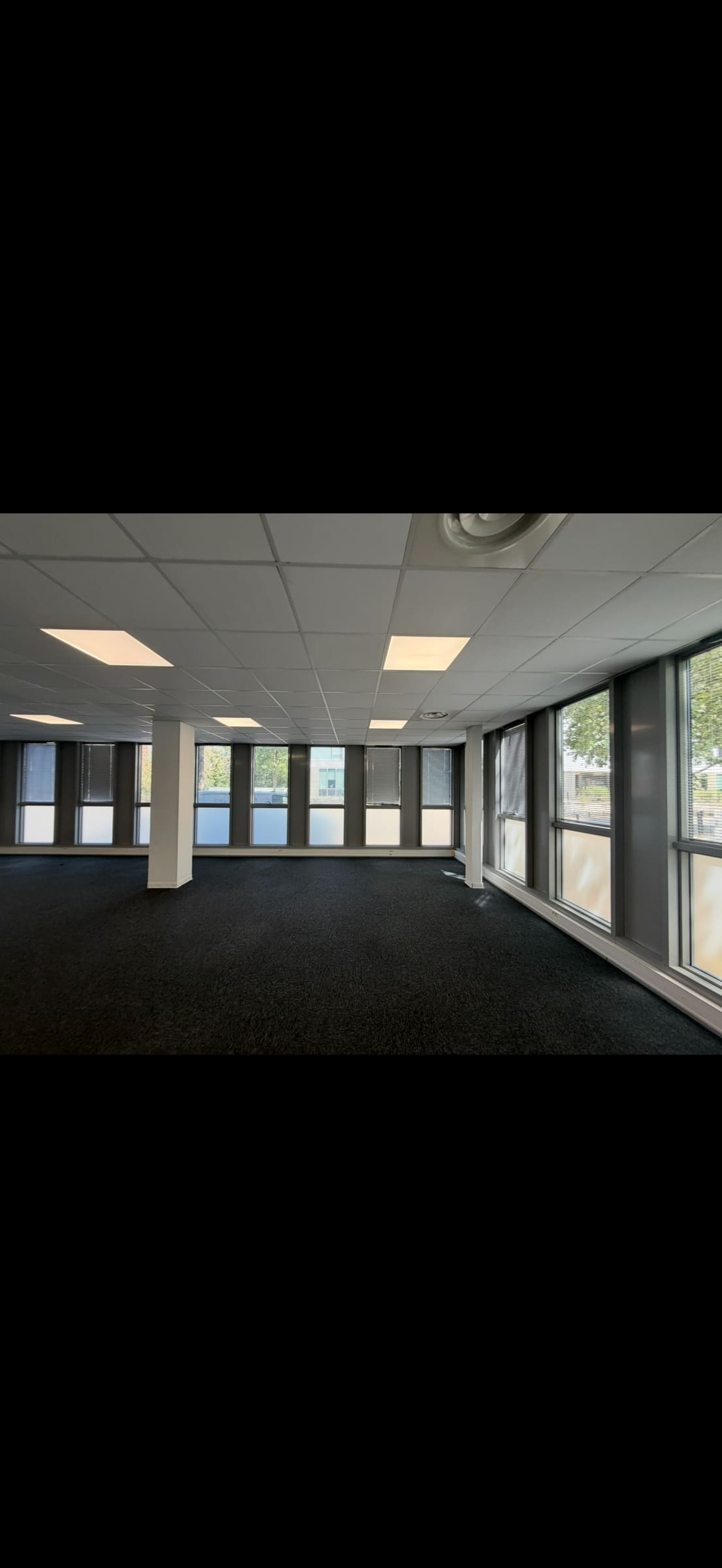 Plateau de bureaux éclairé par des dalles LED encastrées dans le faux plafond