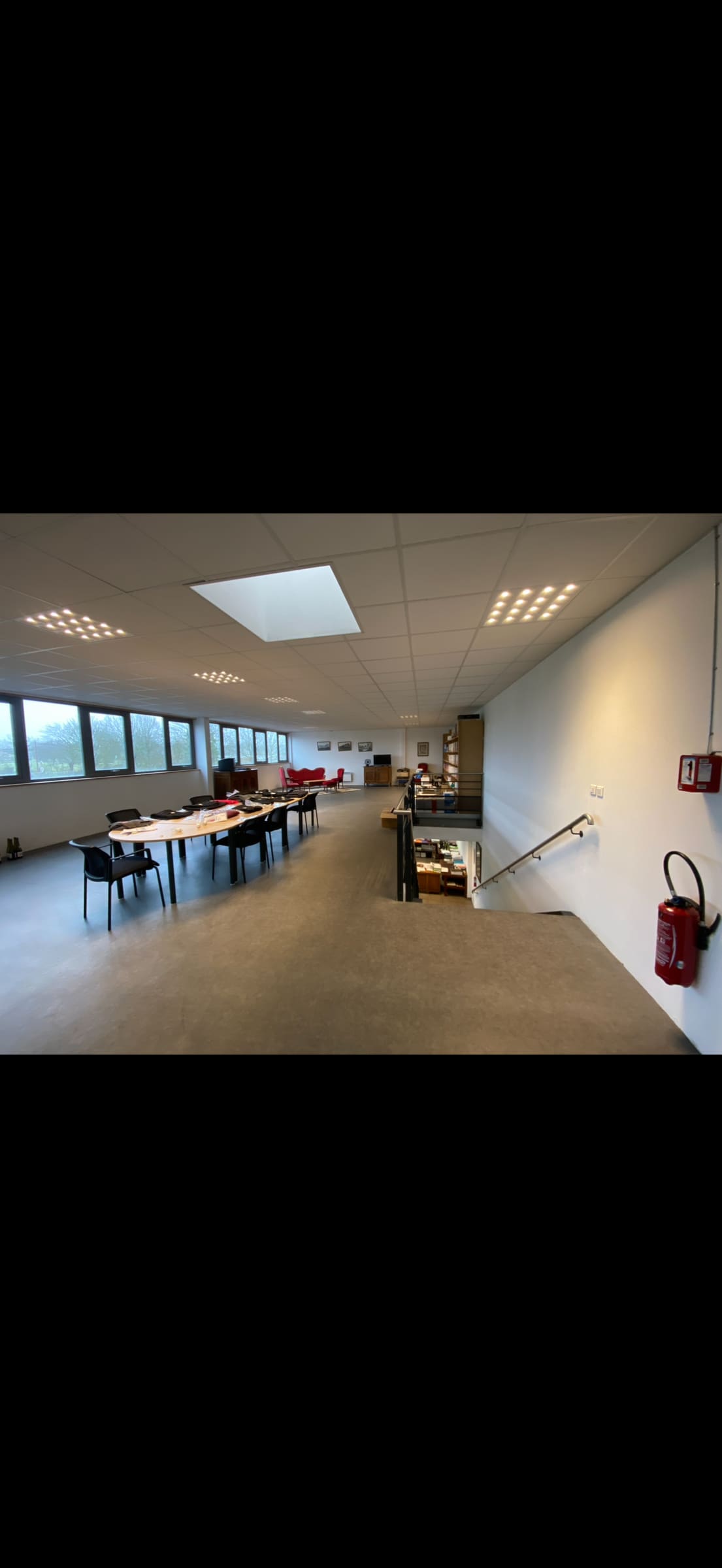 Grand plateau de bureaux avec mezzanine, dalles LED et lanterneau au plafond